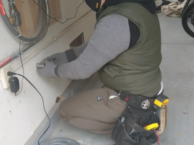 Electrician performing outlet wiring in a Ripley garage